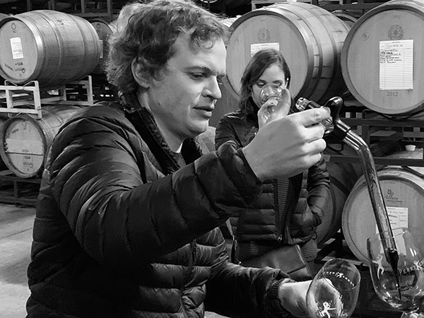 Scott collecting a wine sample from the barrel.